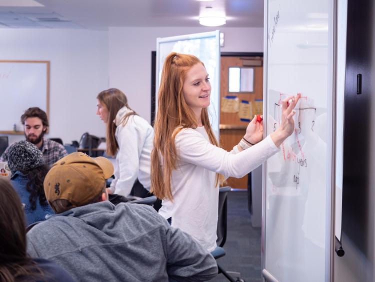 student writing on whiteboard
