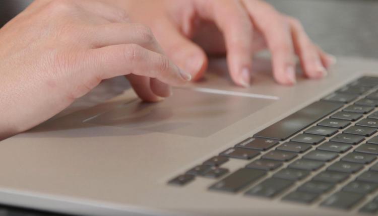 Hands typing on a laptop