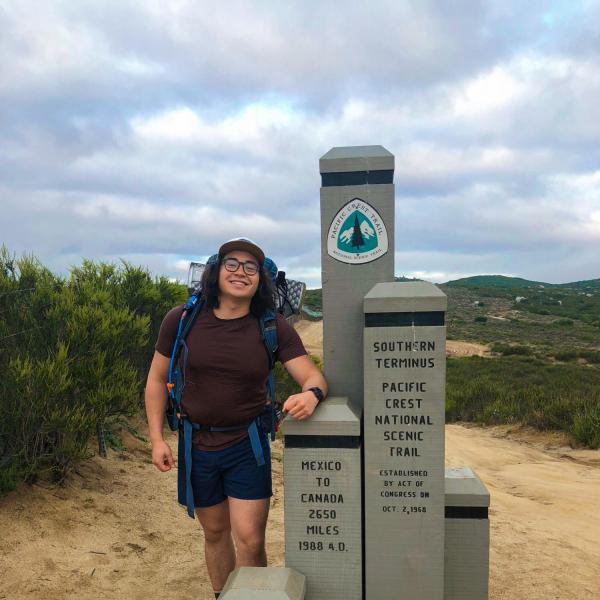 Justin Wang standing at trail-head of Pacific Coast Trail