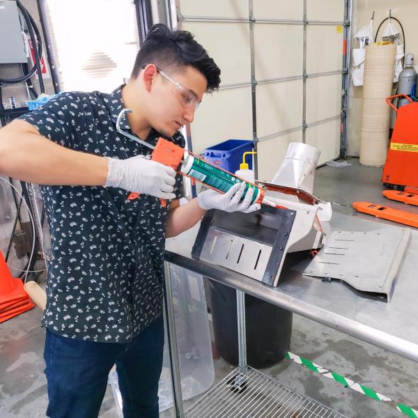 Student using a glue gun on hardware project