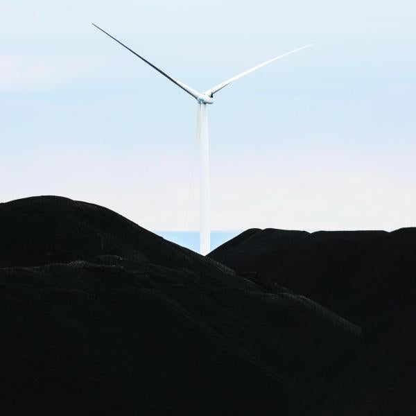 A wind turbine set in front of a blue sky