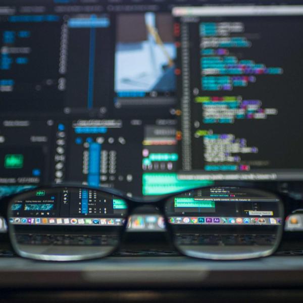 Glasses in front of computer screens with code displayed