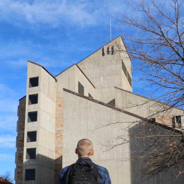 Student in front of CU Boulder Engineering building entrance