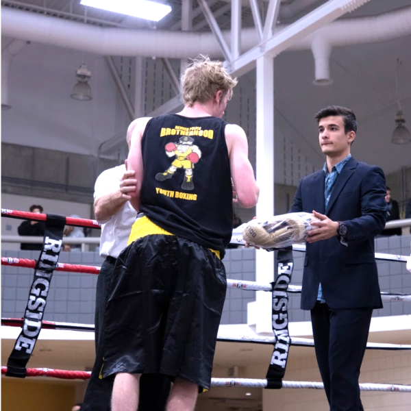 Two students are awarded boxing gloves in boxing ring