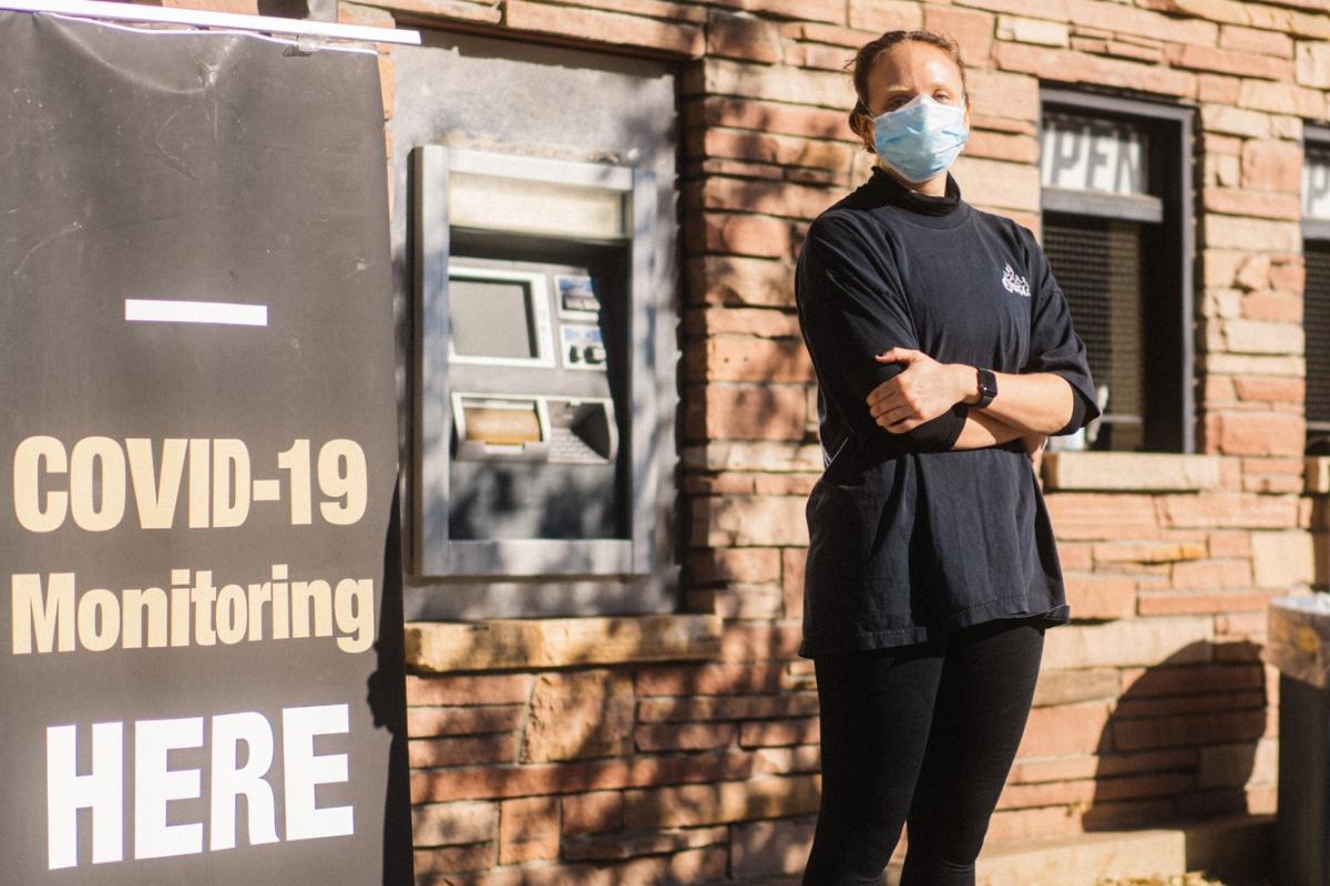 Photo by Elliot Whitehead. Molecular, Cellular and Developmental Biology student Helen Bassett stands in front of the Folsom Field COVID-19 testing site where she works.