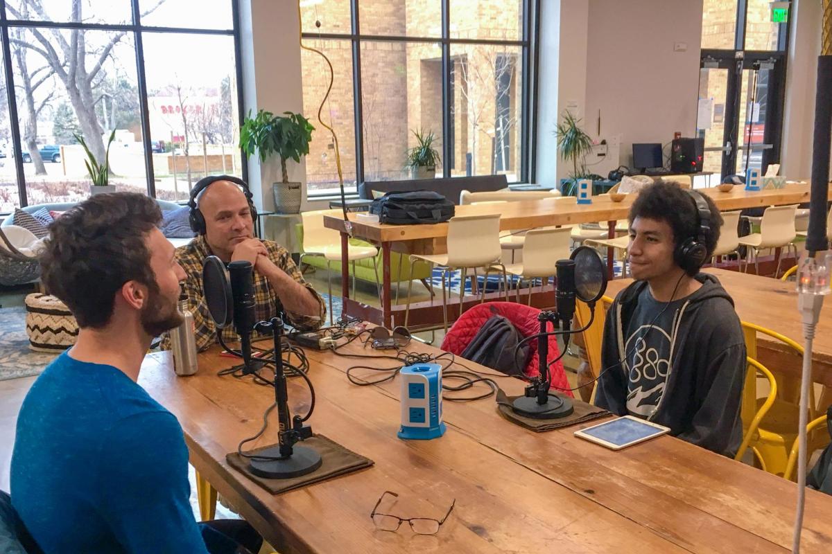 Three podcast students sitting at table