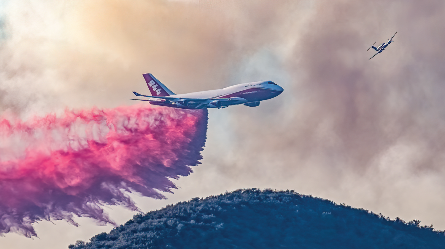 A T-944 Lead B 9 1 plane flies in front of the Global Supertanker at the Apple Fire in Riverside, California. Photo Courtesy of Steve_San_Diego