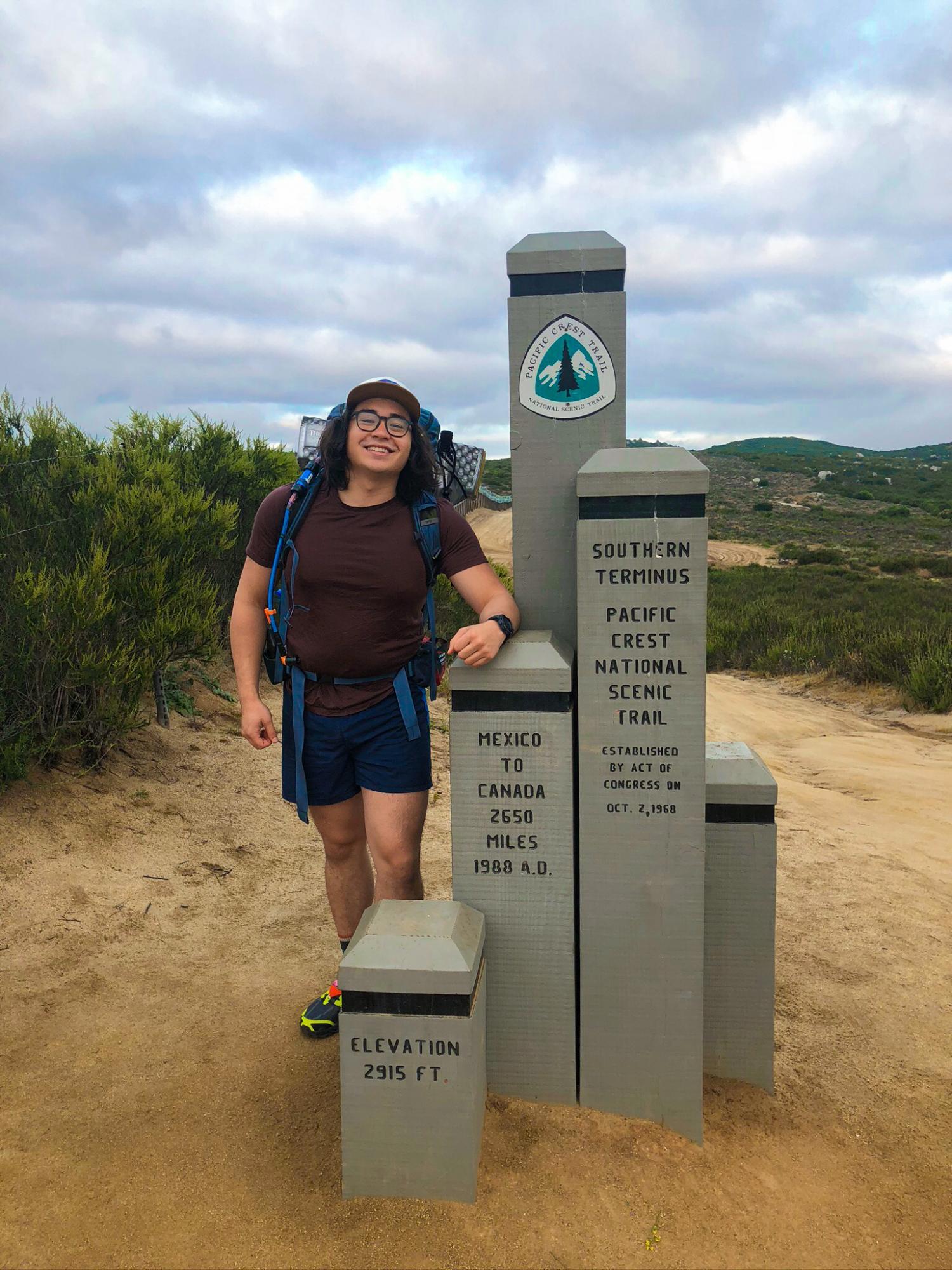 Justin Wang standing at trail-head of Pacific Coast Trail
