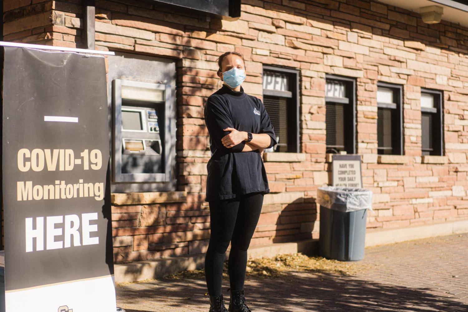 Photo by Elliot Whitehead. Molecular, Cellular and Developmental Biology student Helen Bassett stands in front of the Folsom Field COVID-19 testing site where she works.