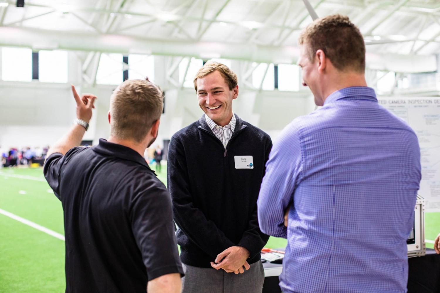 Student and judges speaking inside CU Boulder indoor stadium