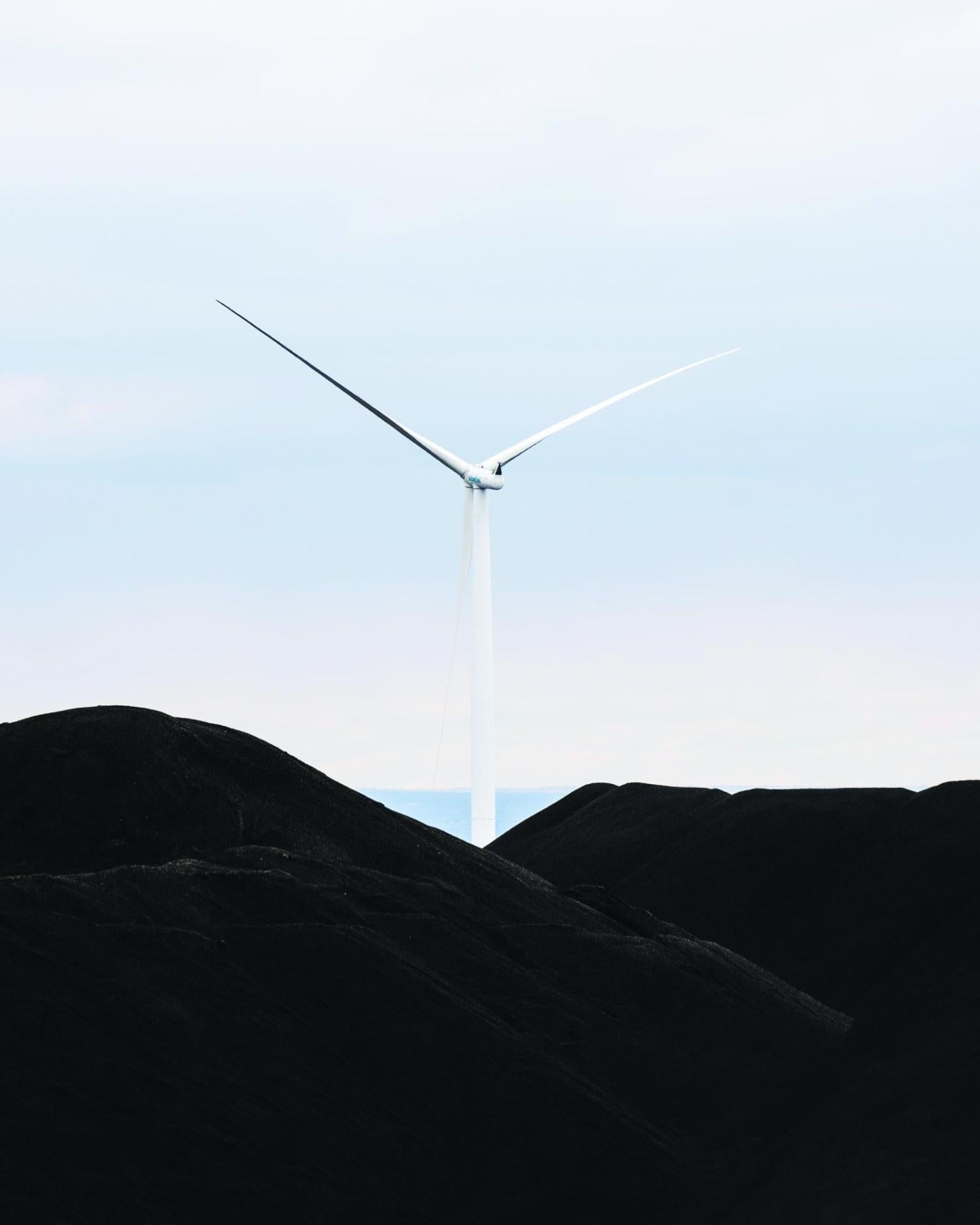 A wind turbine set in front of a blue sky