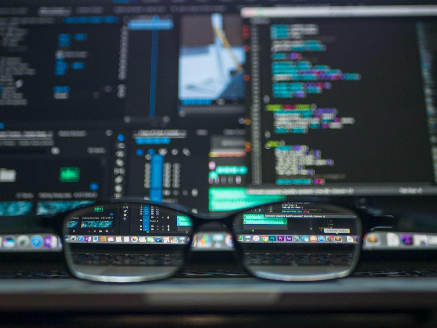 Glasses in front of computer screens with code displayed