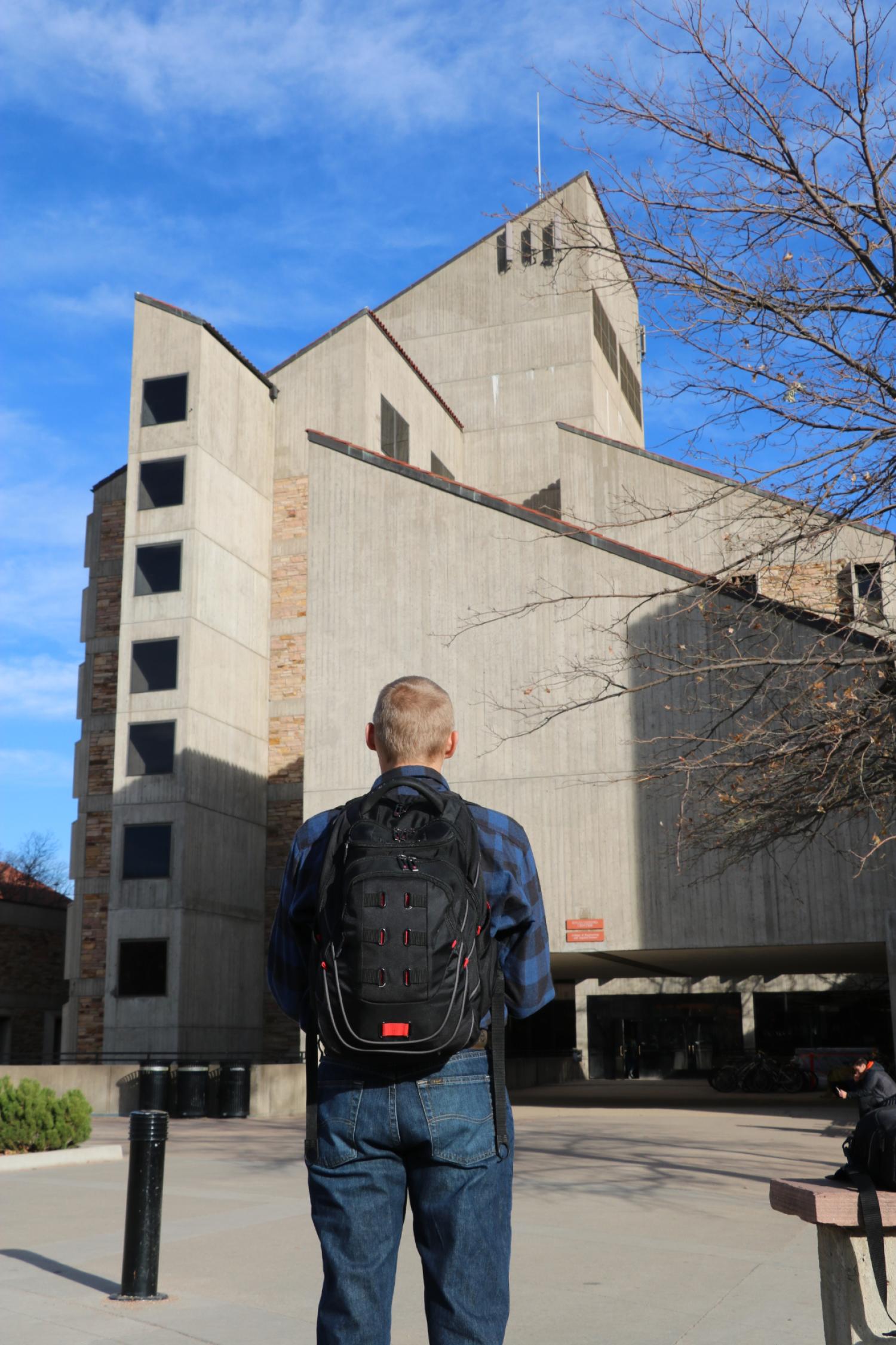 Student in front of CU Boulder Engineering building entrance