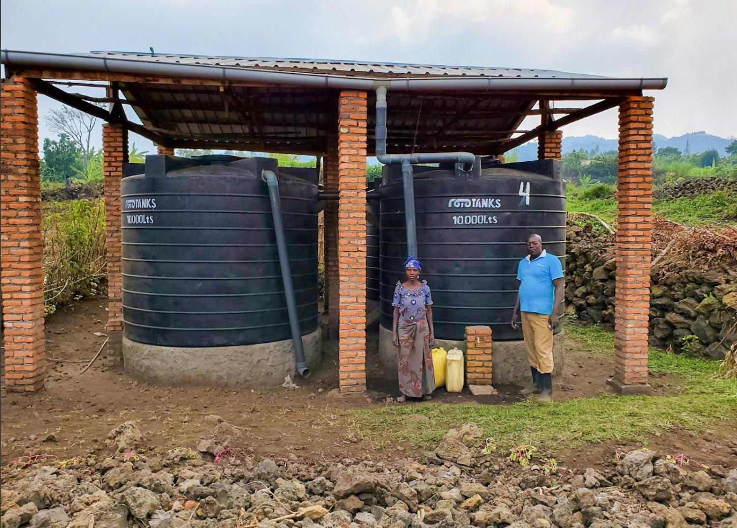 Two people standing under metal shack