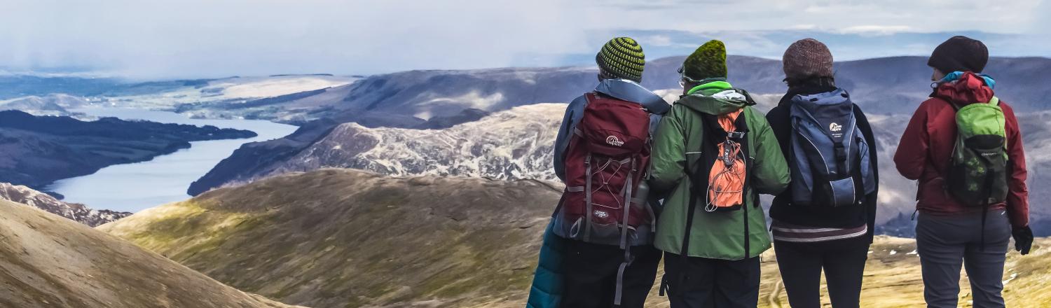 4 female backpackers overlooking mountain valley