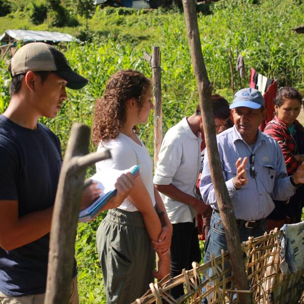 Students in a village taking a survey of the toilet project by a village resident.