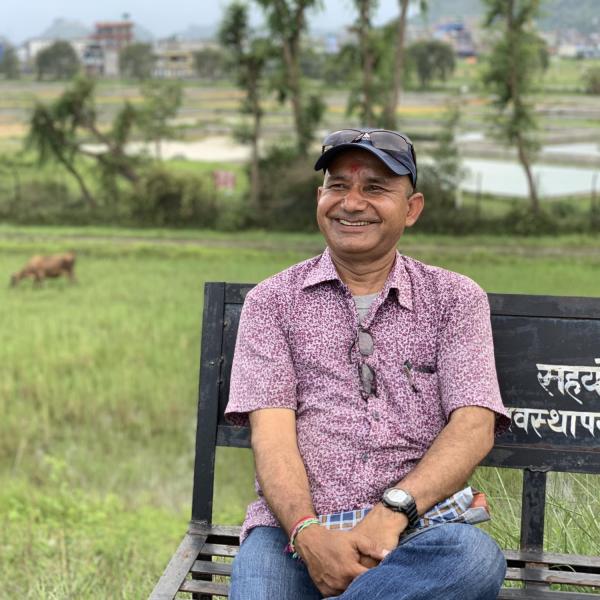 A man smiling off into the distance.