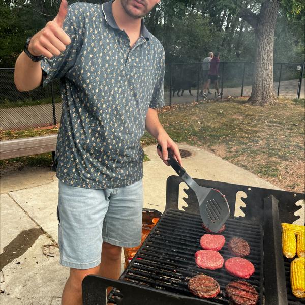 Picture of a grad student grilling burgers.