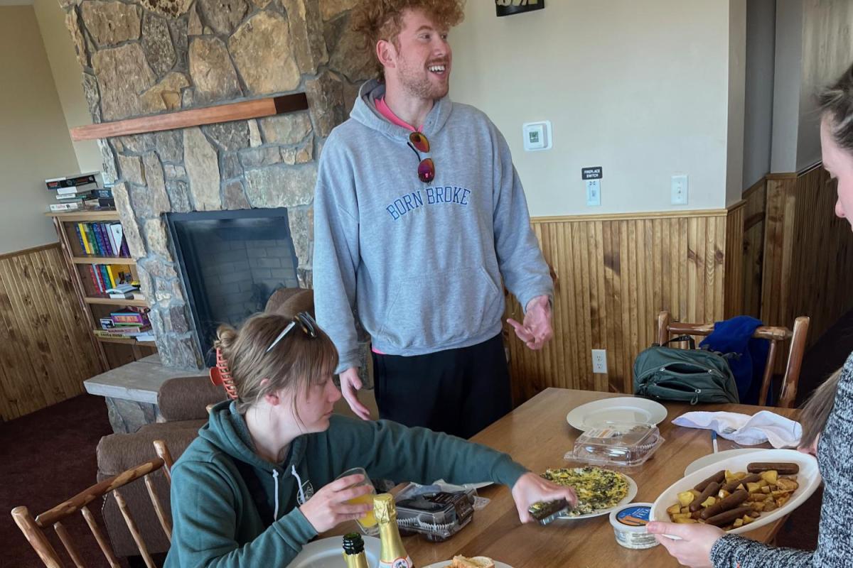 three people gathered around a communal breakfast table