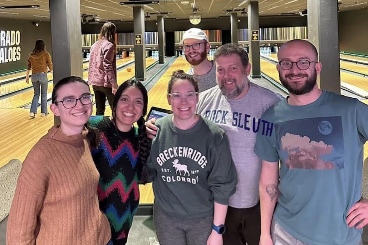 a group of people standing in front of bowling lanes