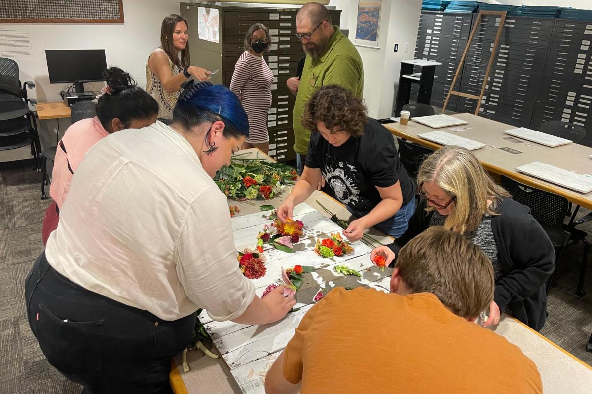 a group of people gathered around a table working on a project
