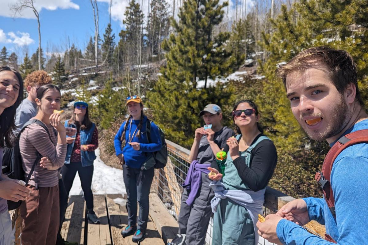 group of people standing on a trail bridge looking at the camera