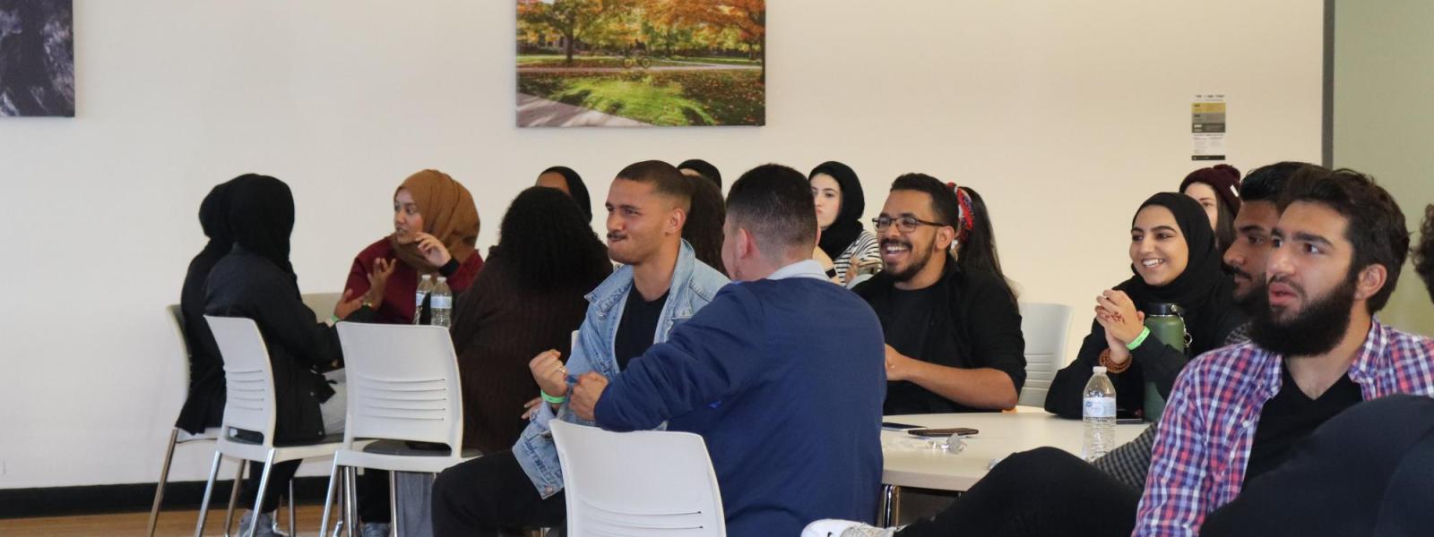Students sitting in tables talking with each other
