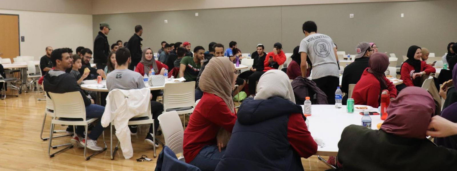 Students sitting tables talking with each other