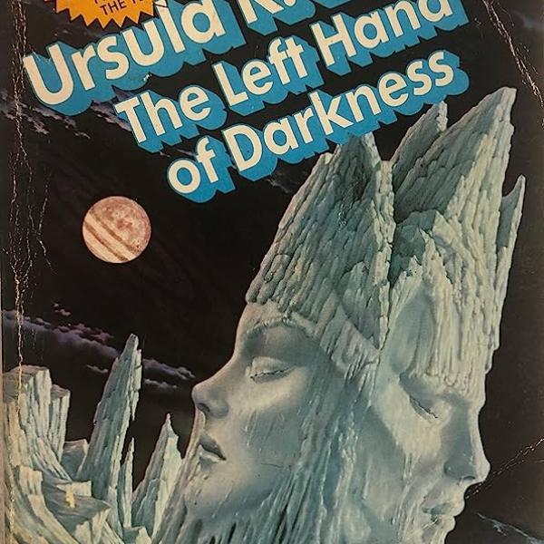 Cover of The Left Hand of Darkness. It features a dark, icy landscape with a large sculpture of a humanoid head with two faces, one feminine and one masculine.