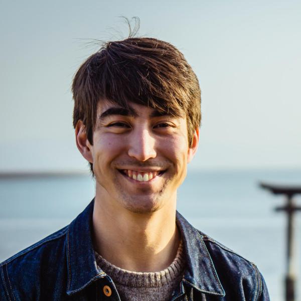 Photo of Josh, light-skinned Japanese man with dark hair framing his face.
