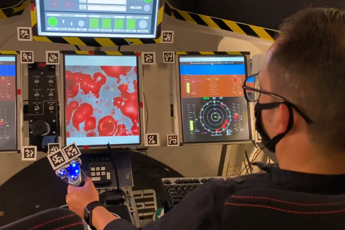 Latino male operates rocket landing simulator in aerospace lab