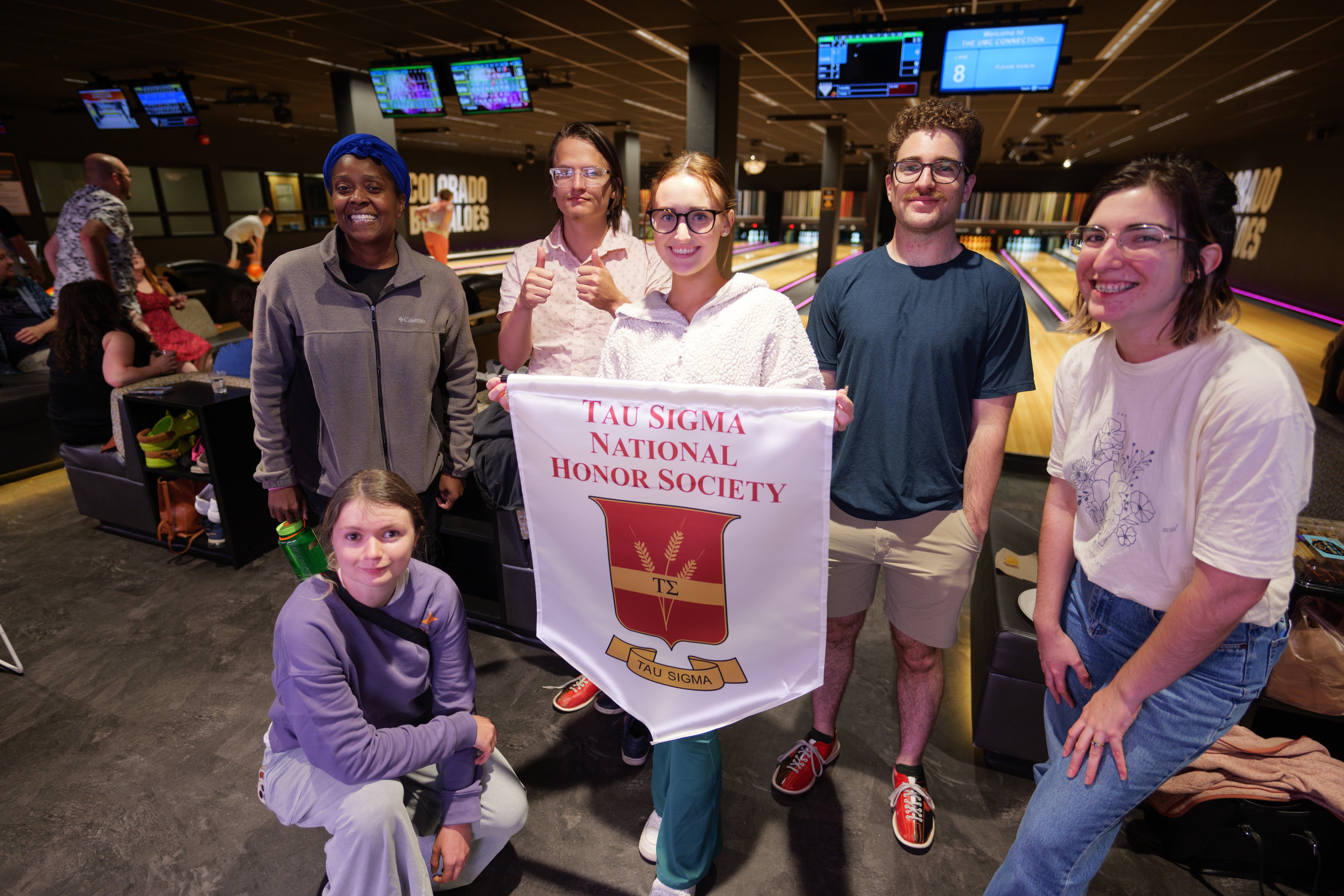 students with tau sigma banner