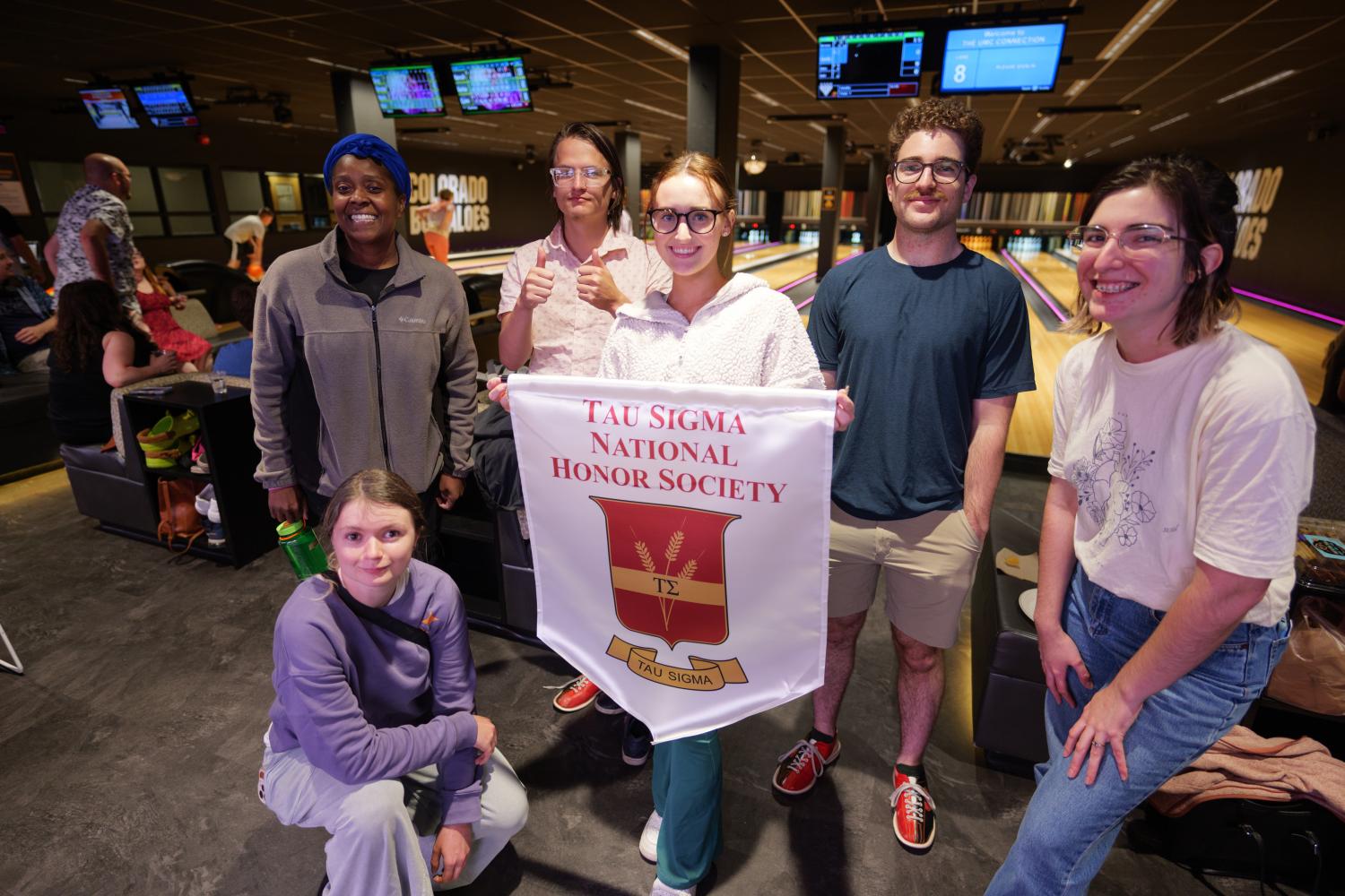 students with tau sigma banner