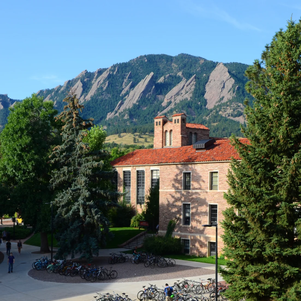 Students walking around campus with the flatirons in the background