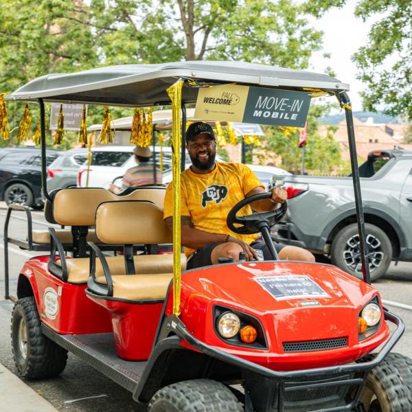 volunteer driving golf cart at move-in