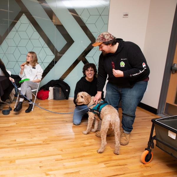 Students interact with a therapy dog at the Gratitude Fair