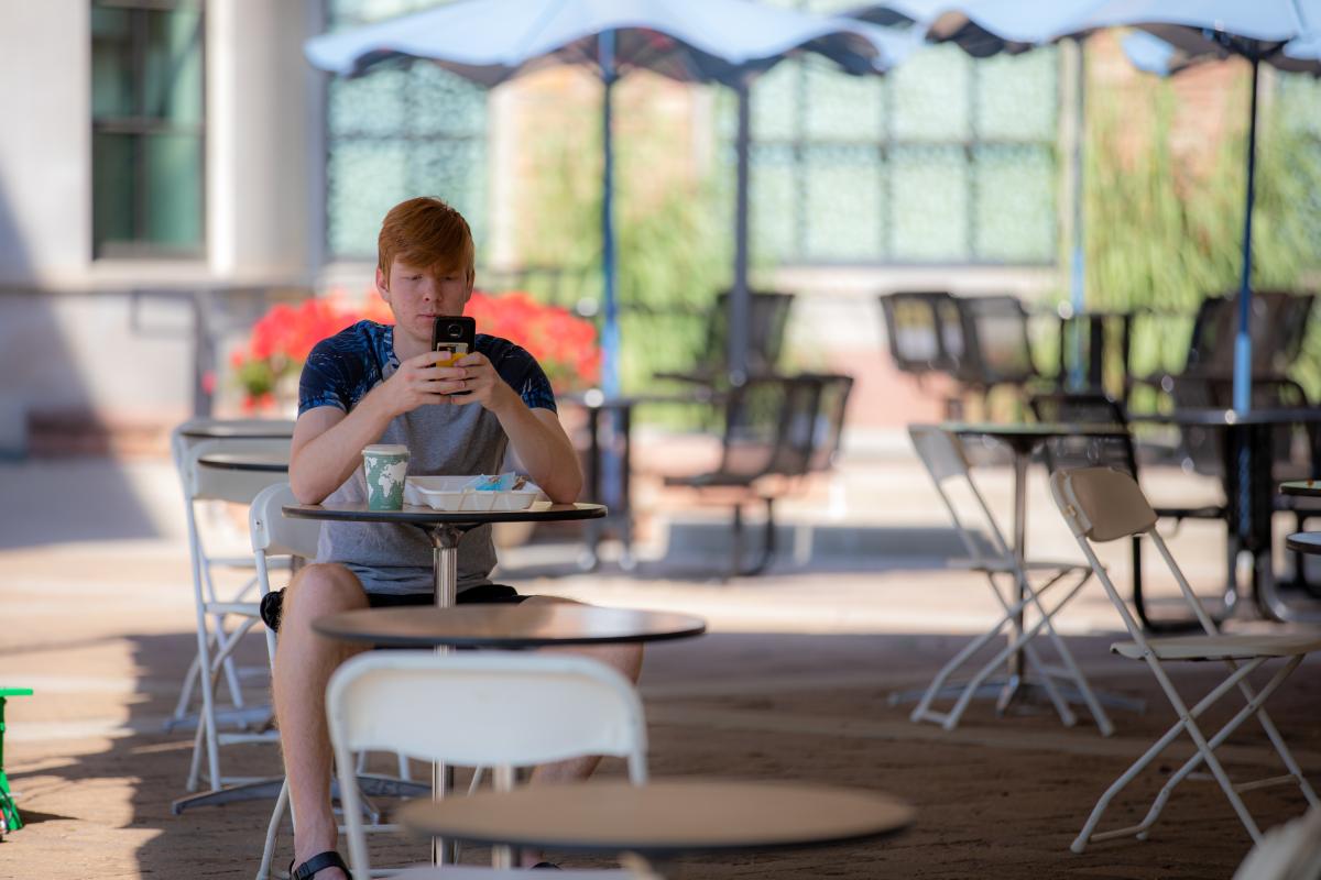 A student on campus looking at a phone