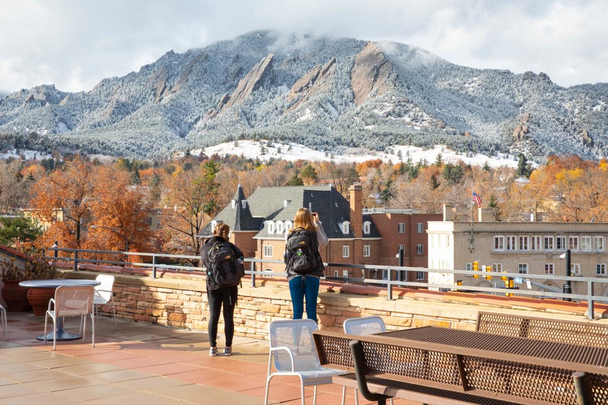 Students take photos of the snowy Flatirons