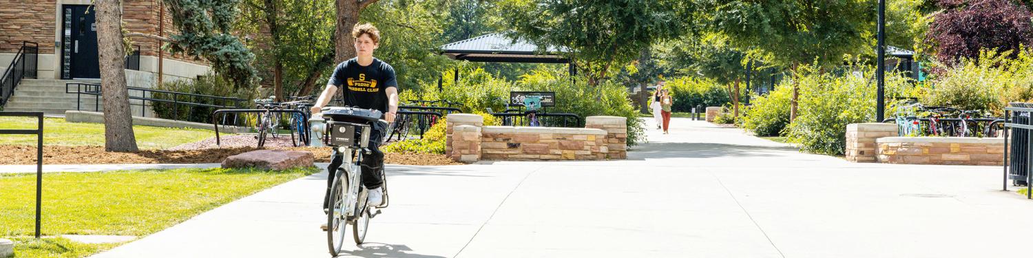 A student biking on campus
