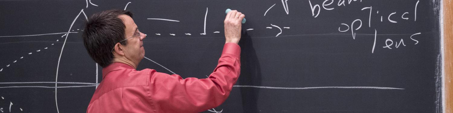 A professor writing on a chalk board