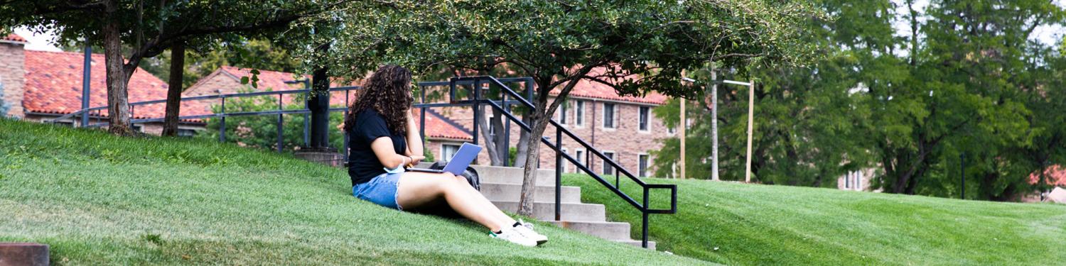 A student sitting outside in the lawn