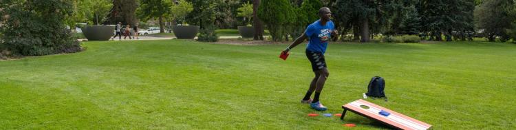 A student plays cornhole on campus