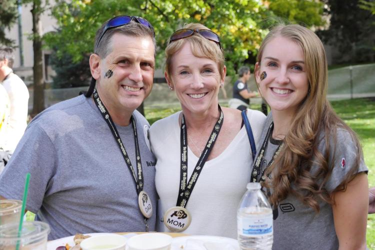 A CU Boulder student and their family members attend a 2017 Family Weekend tailgate event.
