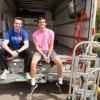 Two students sit in a moving truck