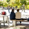 Two students sitting at a picnic table outside the Center for Community building