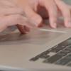 Hands typing on a laptop