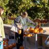 student next to a table of pumpkins