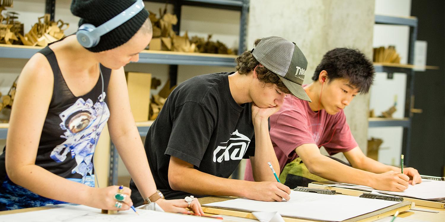 three students working in a studio art class