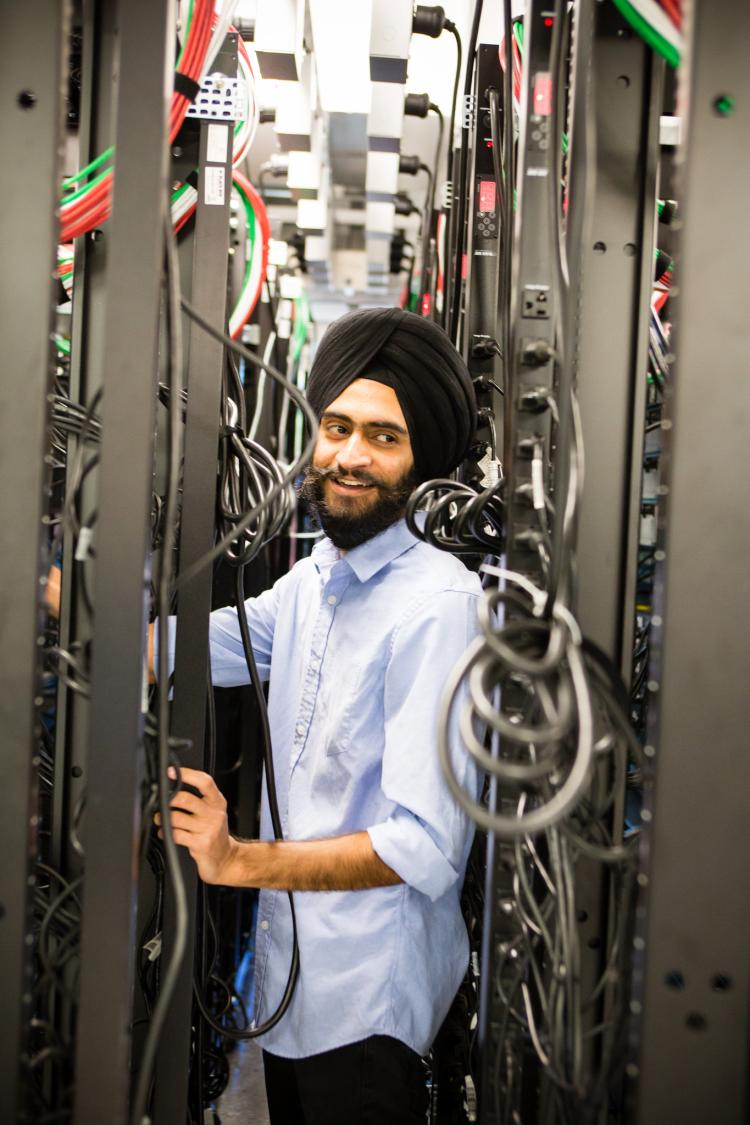 International graduate student, Snehpal Singh Saini, photographed amongst telecommunications equipment.