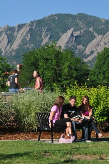 students sitting outside with the mountains in the background